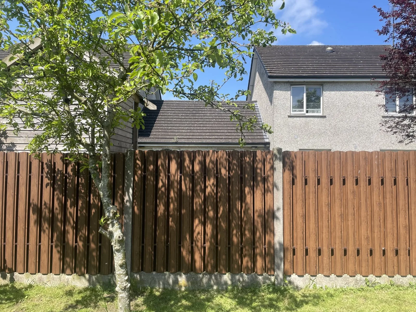 The same garden after F and G fitted steel boards into the existing concrete posts