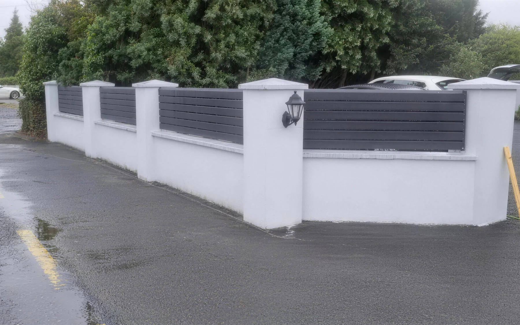 Rendered pillar wall with grey steel slat infill panels